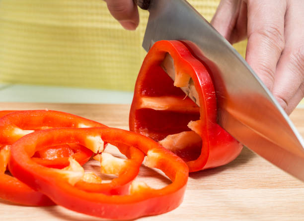 istock A woman's hand slices a red bell pepper 661989102