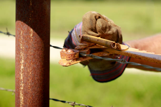Isolated fence pole with orange tape - on a farmers field
