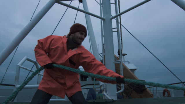 Serious Seaman Pulls the Thick Rope during Traveling on the Ship