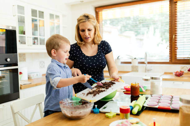 istock Child helping mother prepare muffins in kitchen 662033740