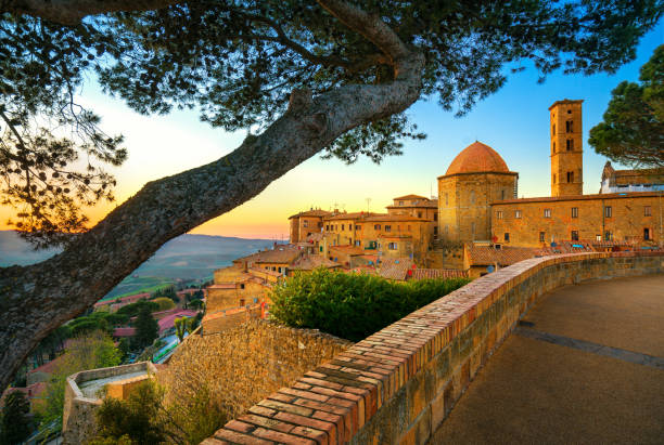 toscane, horizon de la ville de volterra, église et arbres au coucher du soleil. italie - chianti region photos et images de collection