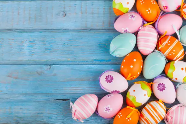 Photo of Colorful easter eggs on turquoise wooden table