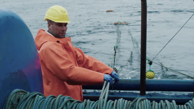 Fisherman Works on Commercial Fishing Ship that Pulls Trawl Net