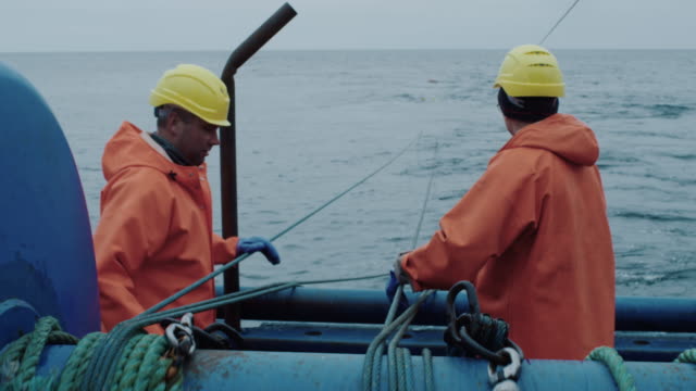 Fisherman Works on Commercial Fishing Ship that Pulls Trawl Net