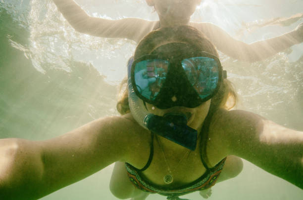 istock Child playing with mother underwater taking selfies 662112962