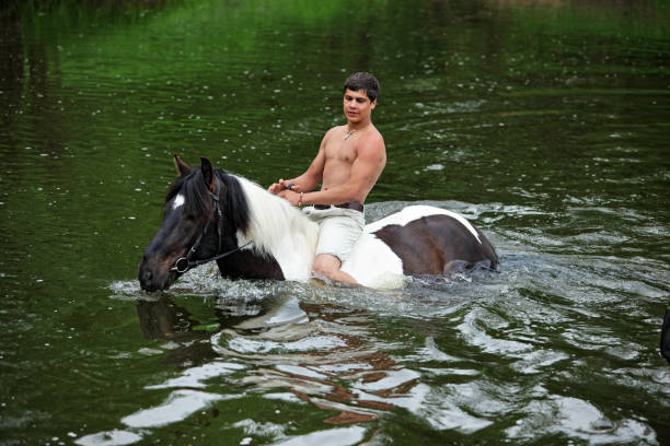 satisfied farm worker hugging his white horse