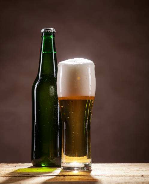 istock Beer bottle and mug on brown background 662122186