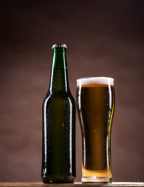 istock Beer bottle and mug on brown background 662122198