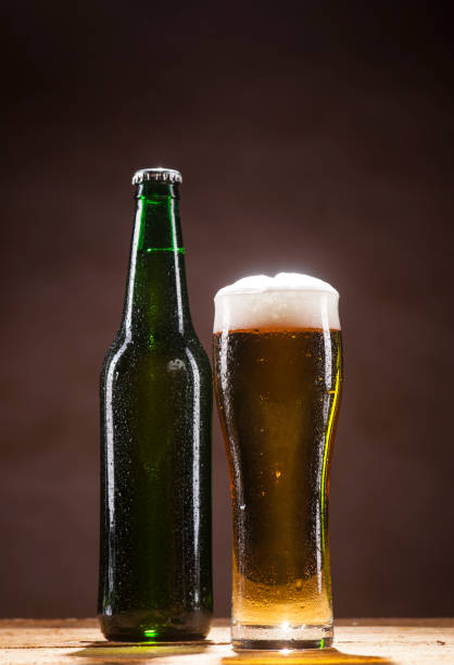 istock Beer bottle and mug on brown background 662122224