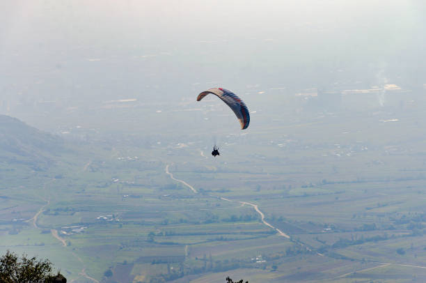 istock Unrecognizable people paragliding in the mountains over valley 662168636