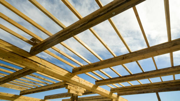 Installation of wooden beams at construction the roof truss system of the frame house stock photo