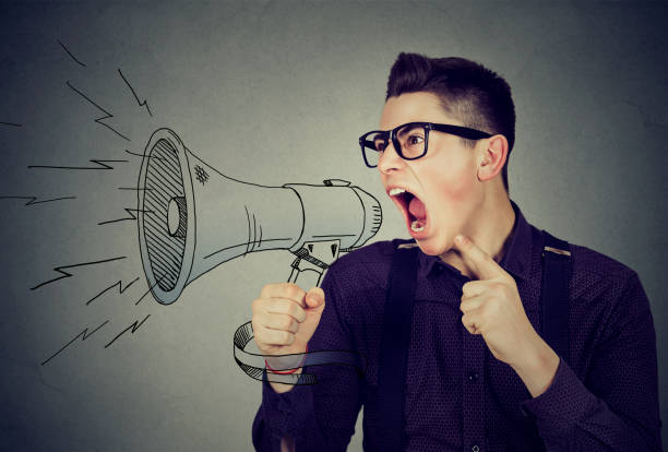 istock Angry young man screaming in megaphone isolated 662209844