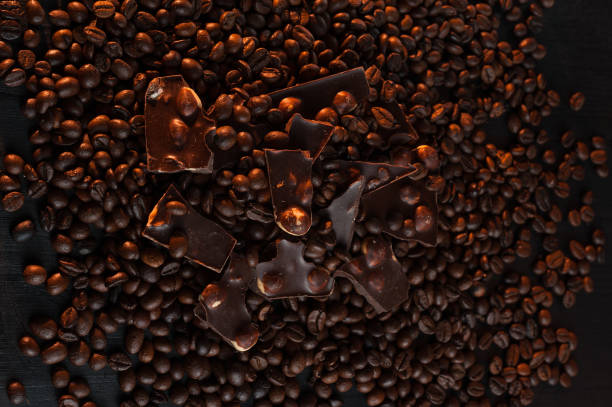 istock Coffee beans with chocolate Broken slices of chocolate fried coffee grains background 662215986
