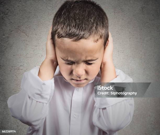 Closeup Portrait Headshot Child Boy Covering Ears With Hands Stock Photo - Download Image Now