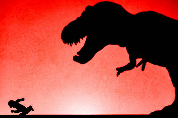 Silhouette of a Dinosaur with a Robot on a red colored background.
