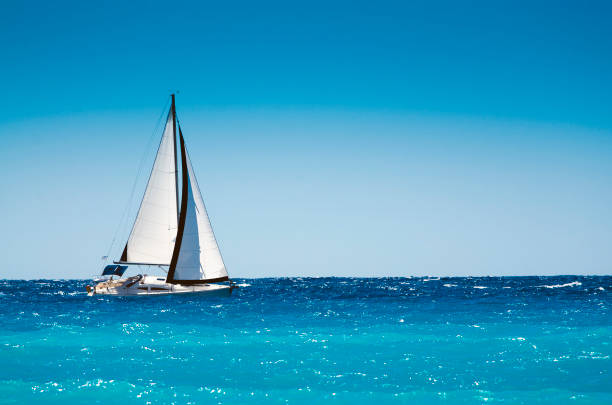 white boat sailing in the open blue sea - sea water single object sailboat imagens e fotografias de stock