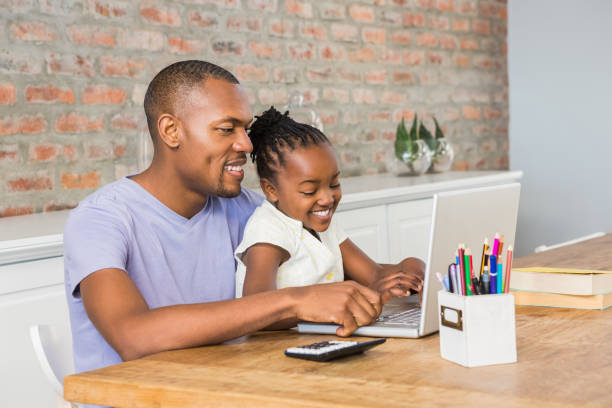 istock Cute daughter using laptop at desk with father 662371216