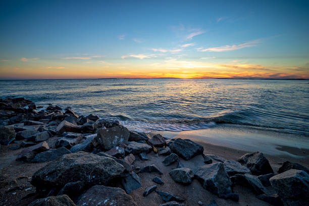 Waves and a jetty at sunset at Edisto beach Waves and a jetty at sunset in the Atlantic Ocean at Edisto beach south carolina edisto island south carolina stock pictures, royalty-free photos & images