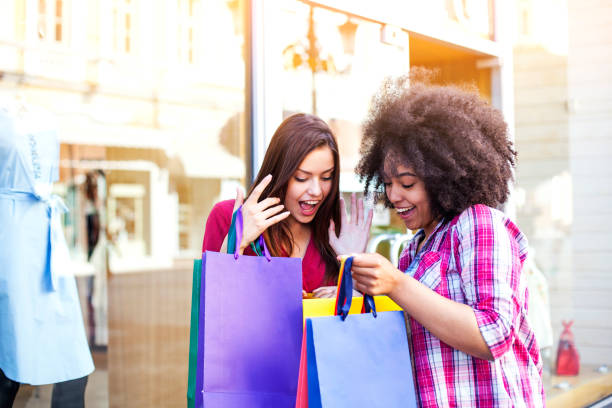 街で買い物をする幸せな女性 - spending money adult african ethnicity bag ストックフォトと画像