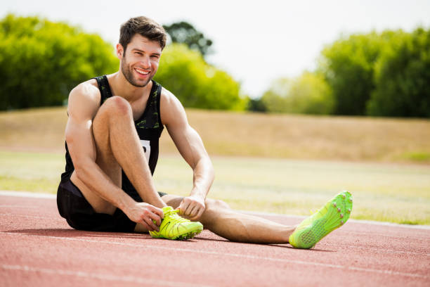 istock Athlete tying his shoe laces on running track 662498148