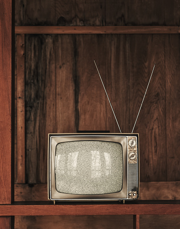 Vintage television with static amidst a rundown home interior.