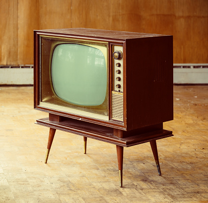 Vintage television amidst a rundown home interior.