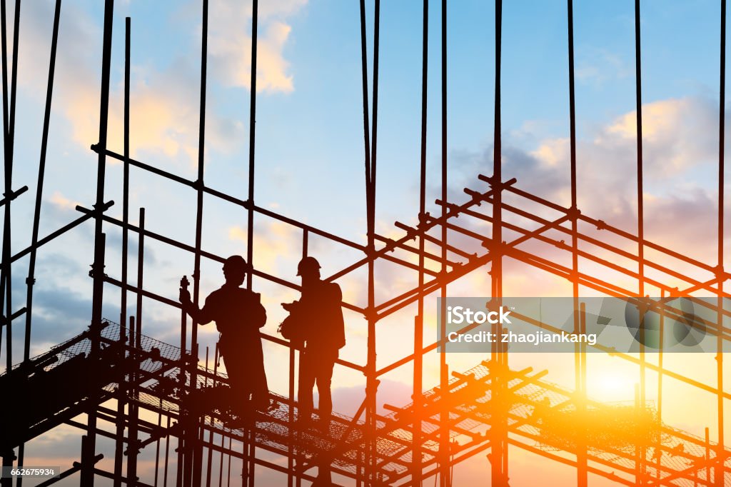 construction worker on construction site construction worker on construction site at sunset Scaffolding Stock Photo