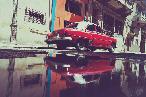 Old American car on street with water reflections, Havana, Cuba