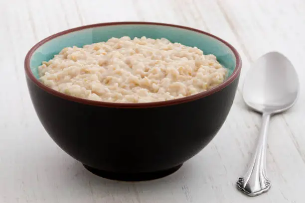 Delicious nutritious and healthy fresh old fashioned oatmeal on antique wood tableDelicious nutritious and healthy fresh old fashioned oatmeal on antique wood table