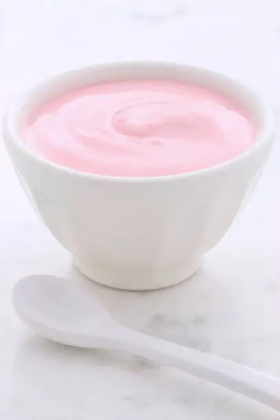 Delicious, nutritious and healthy fresh plain yogurt on vintage carrara marble setting.