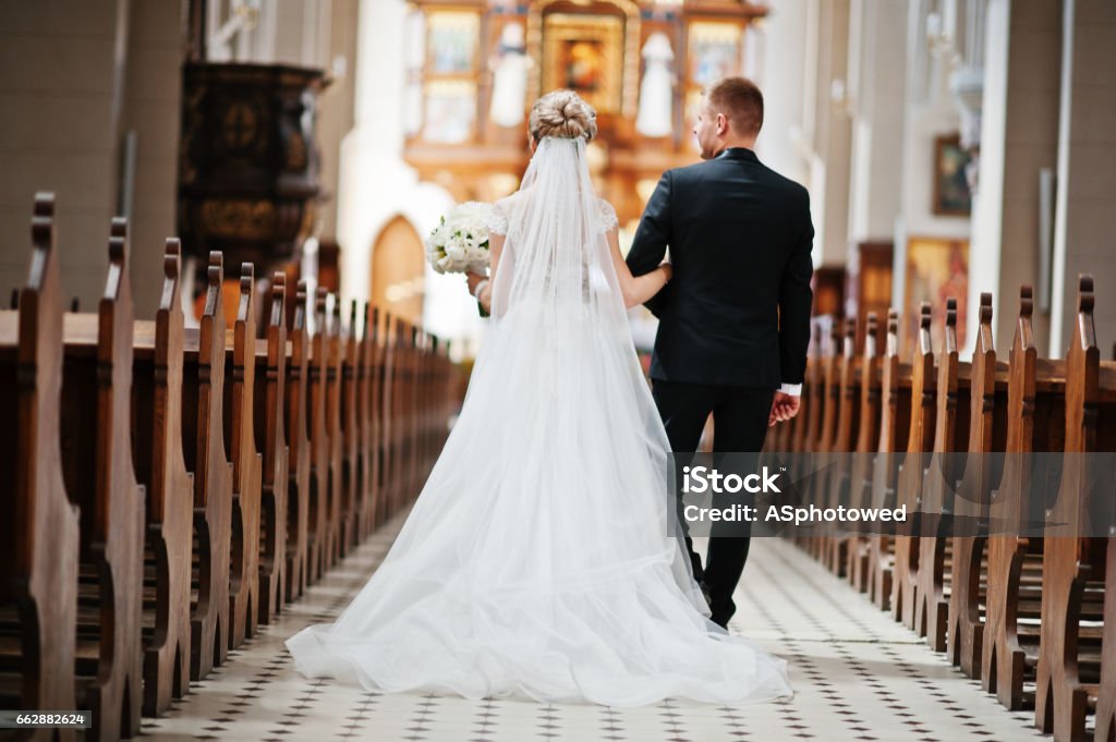 Photosession of stylish wedding couple on catholic church. Wedding Stock Photo