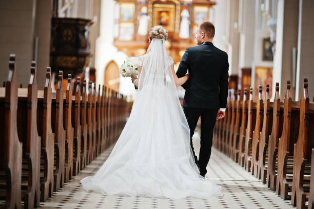 photosession of stylish wedding couple on catholic church. - photography wedding bride groom imagens e fotografias de stock