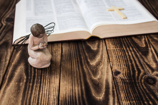 istock angel and bible on wooden background 662914824