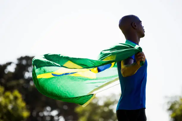 Athlete posing with brazilian flag after victory in stadium