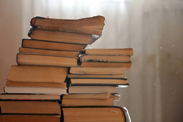 istock Stack of old yellowed books  in a dusty room. 662933996