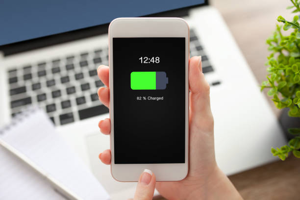 istock female hand holding white phone with charged battery on screen 662935016