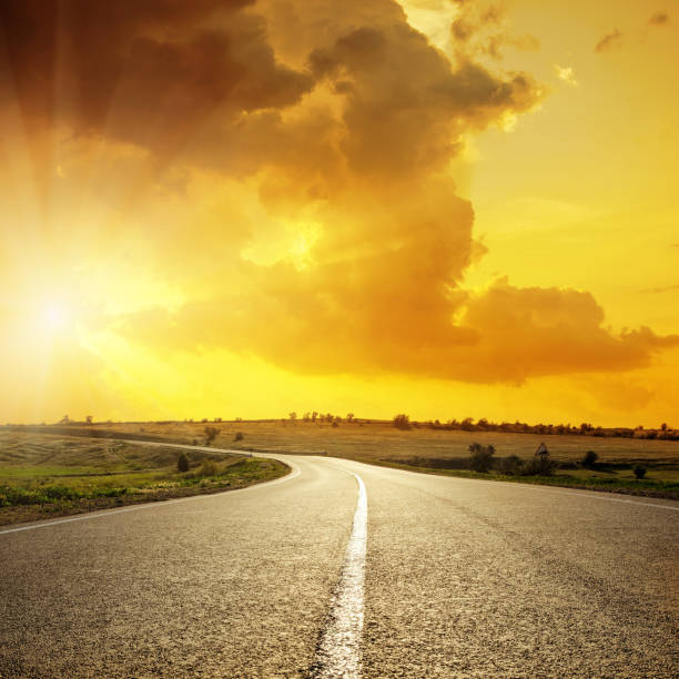 istock orange sunset in clouds over asphalt road 662935820