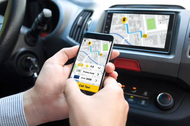 istock man hands in car holding phone with application call taxi 662937378
