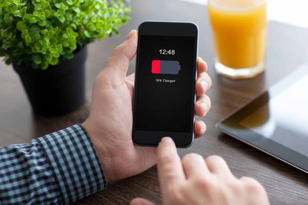 istock man holding phone with low charged battery on screen 662937748