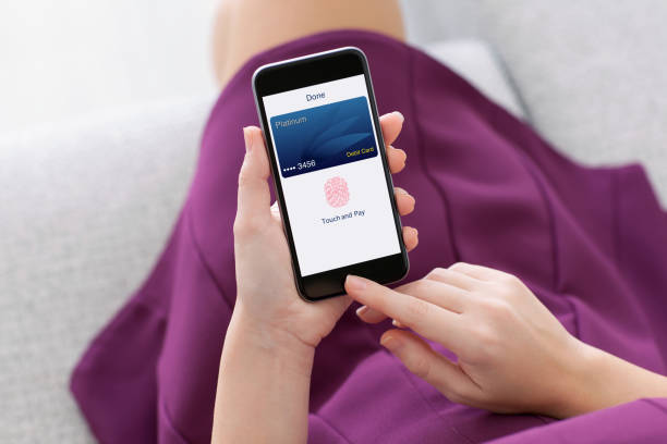 istock woman holding phone with debit card app touch pay 662947300