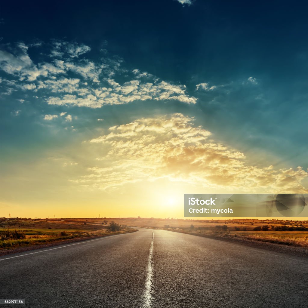 劇的なアスファルトの道路上空で太陽が昇り - 道路のロイヤリティフリーストックフォト