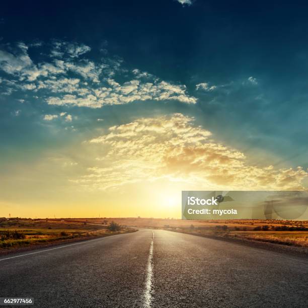 Low Sun In Dramatic Sky Over Asphalt Road Stock Photo - Download Image Now - Road, Sunrise - Dawn, Sunset