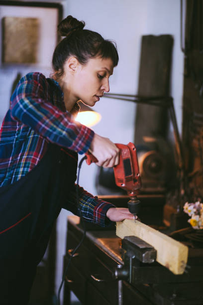istock Artisan, Young Lady Drilling Wood 662985318