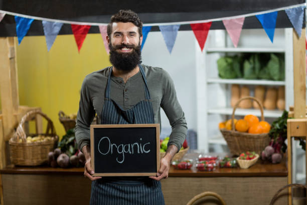 istock Worker holding a board with organic sign at grocery store 662994188