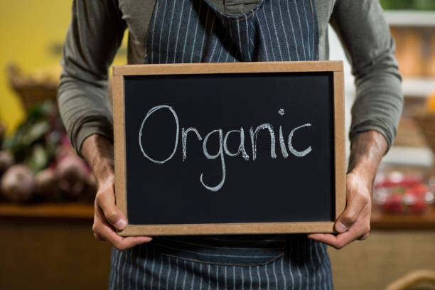 istock Worker holding a board with organic sign at grocery store 662995410