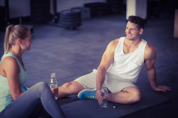 istock Sitting young couple drinking water together 663003114