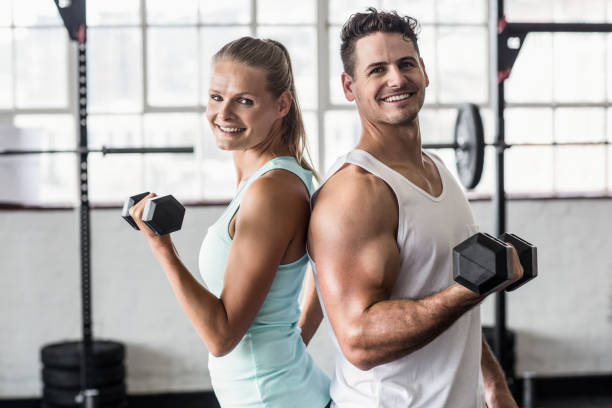 istock Smiling couple exercising with dumbbells 663015130