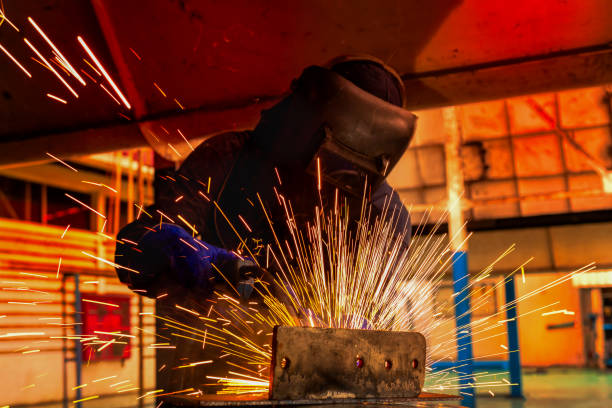 trabajador esté soldando acero parte en fábrica del coche - adult manual worker automobile industry transportation fotografías e imágenes de stock