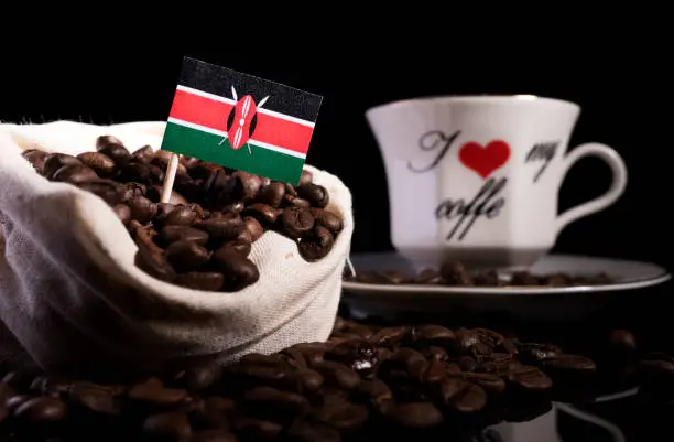 Kenyan flag in a bag with coffee beans isolated on black background