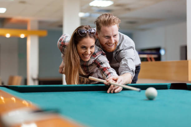 istock Beautiful couple flirting while playing snooker 663103248